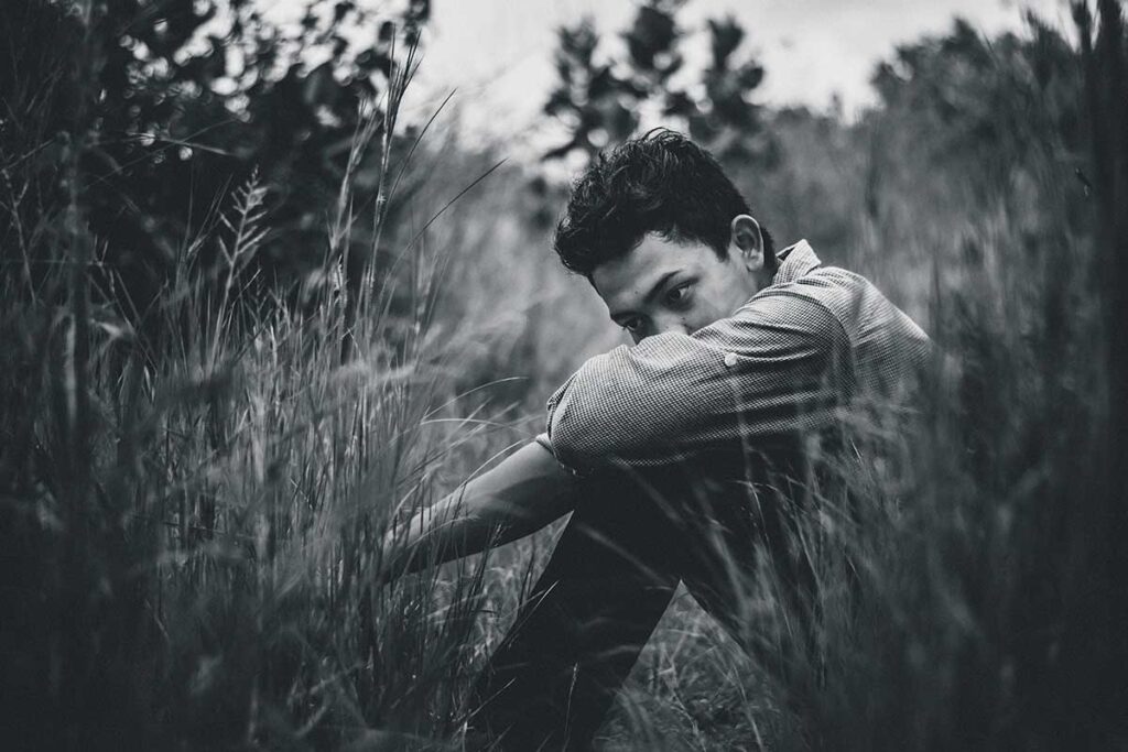 man sitting in a field thinking